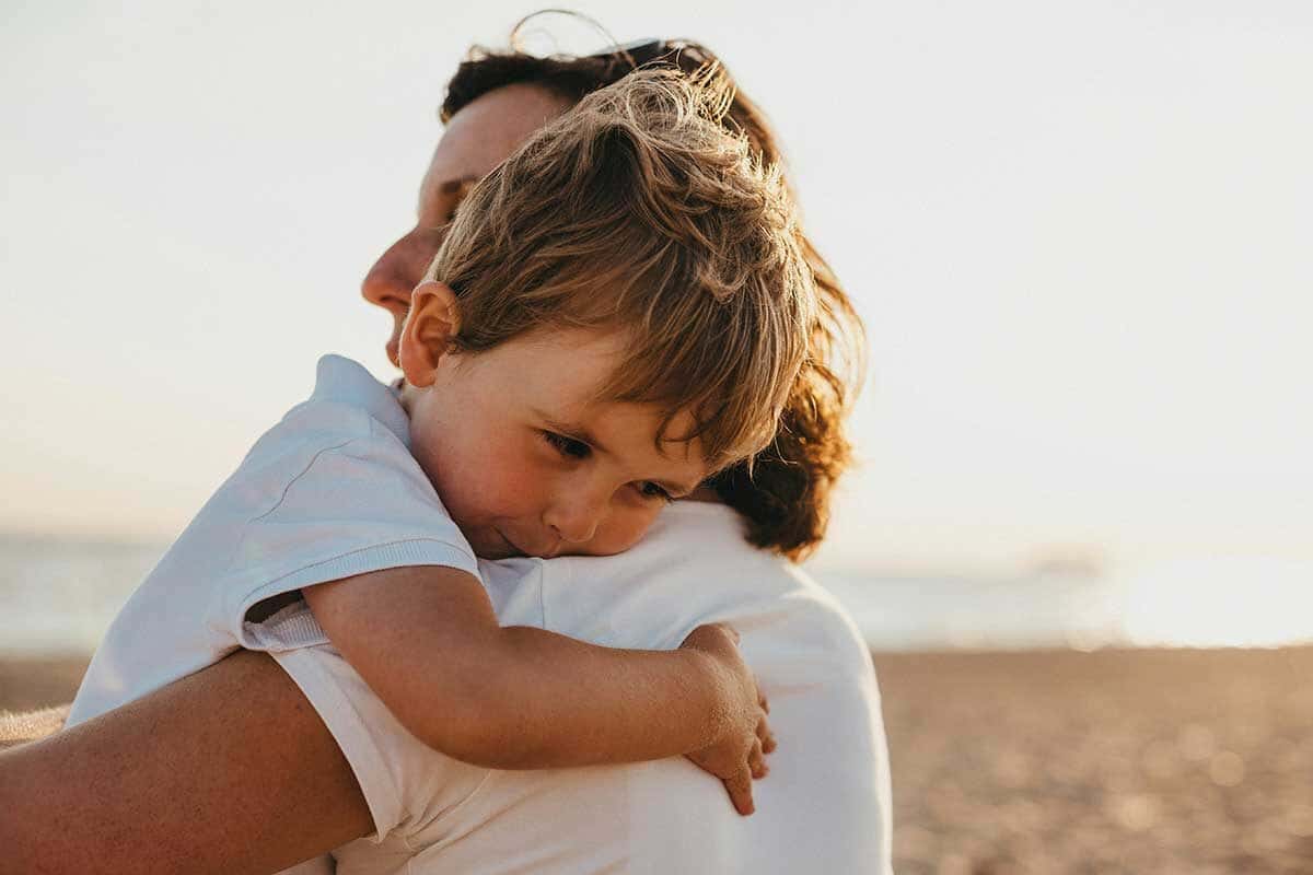 Boy Hugging Woman During Daytime