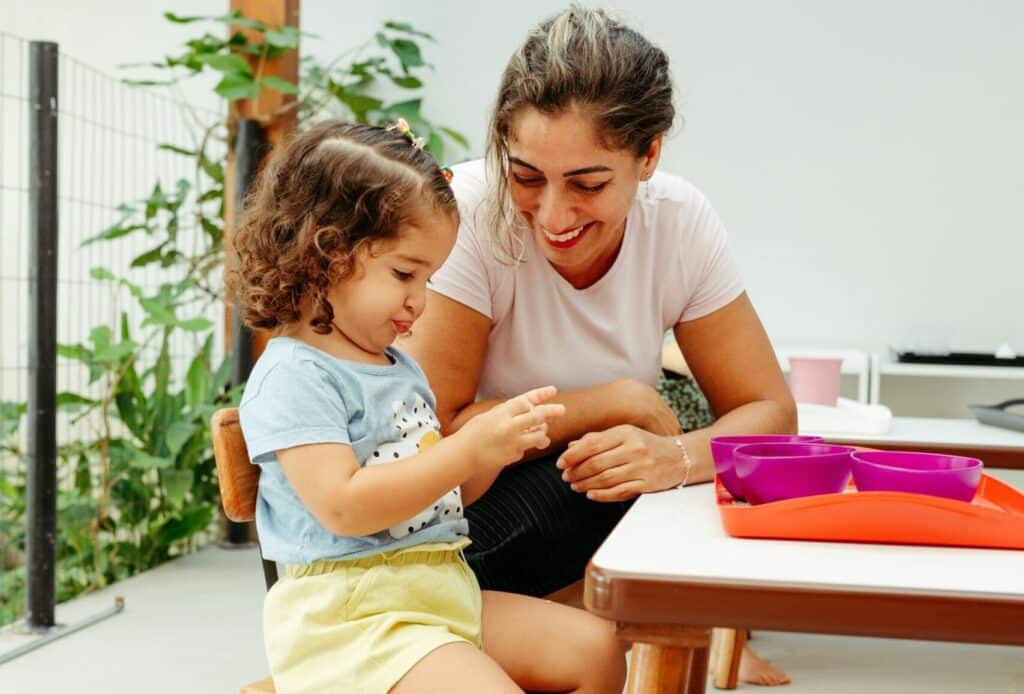 woman sits with young child at table